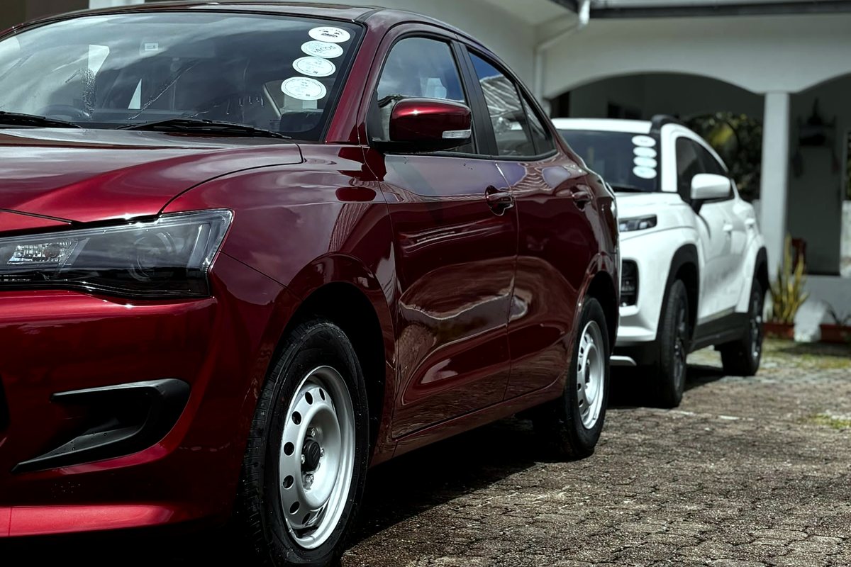 A red Suzuki Dzire parked at a villa on Mahé