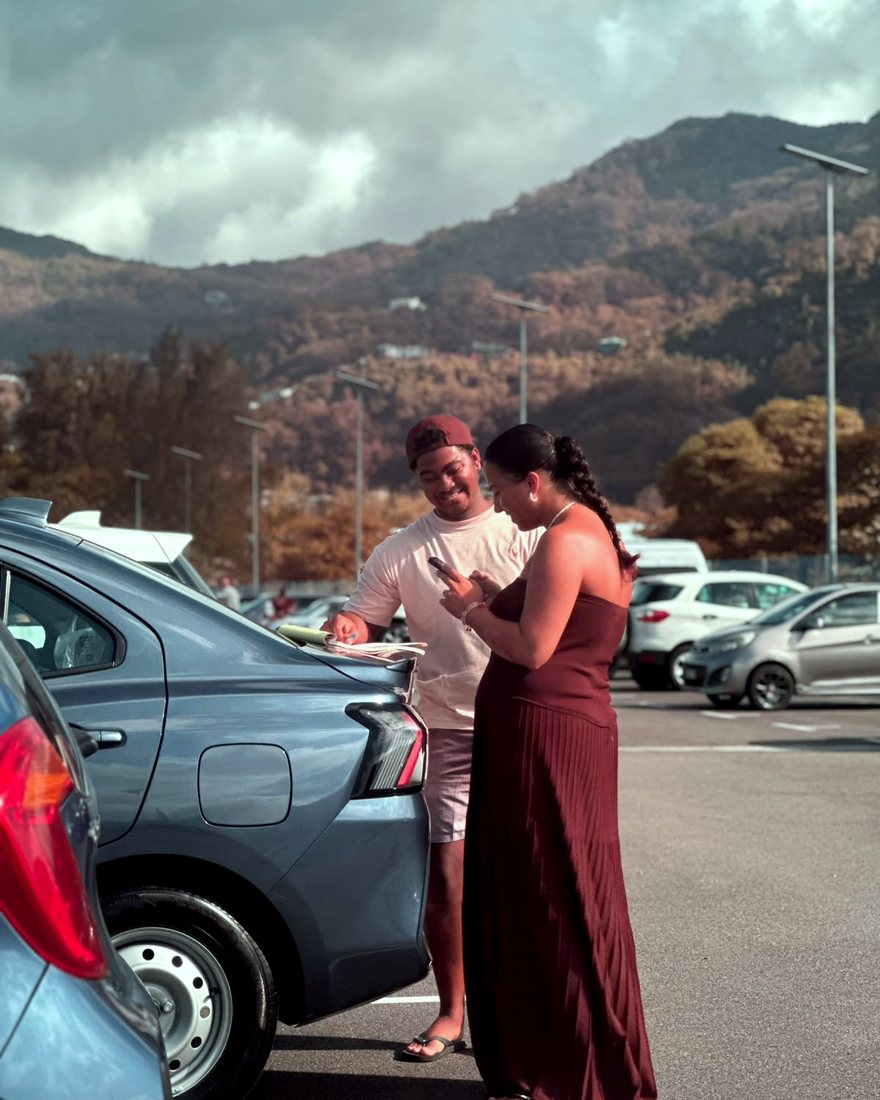 Handing over car keys and paperwork in a Mahé car park